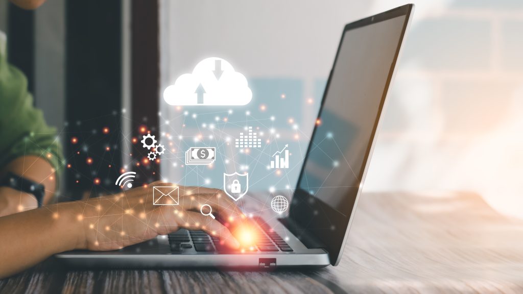 Human hand using laptop with virtual popup icons of cloud computing, wifi, money, cloud storage and email