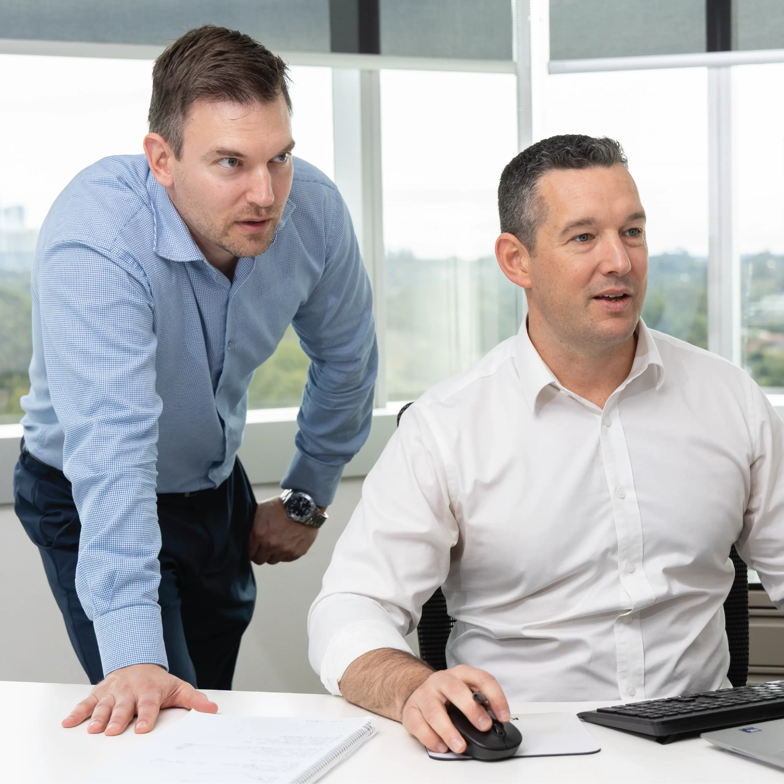 IT experts looking at computer screen, providing Azure cost optimisation.