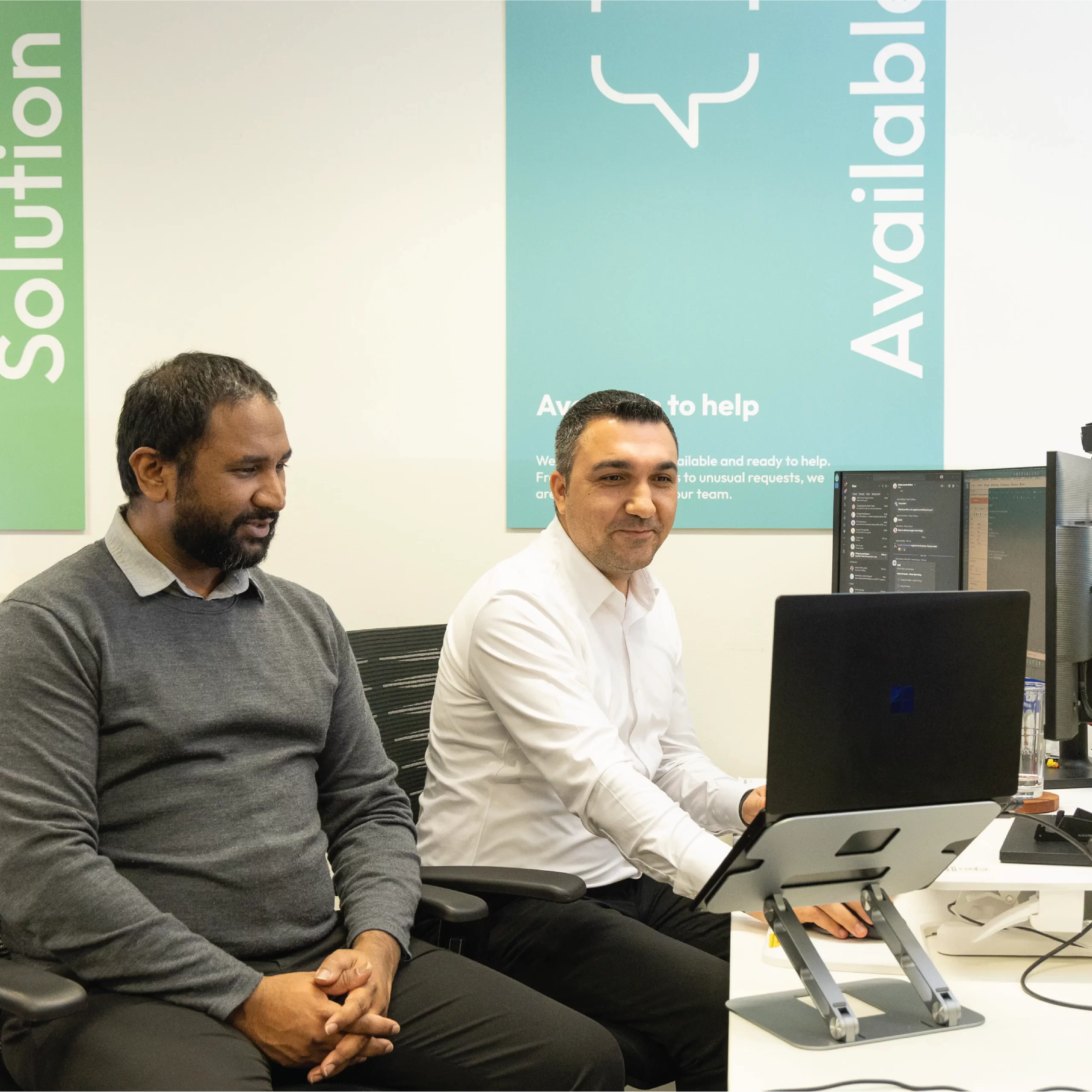 IT specialists looking at laptop screens.