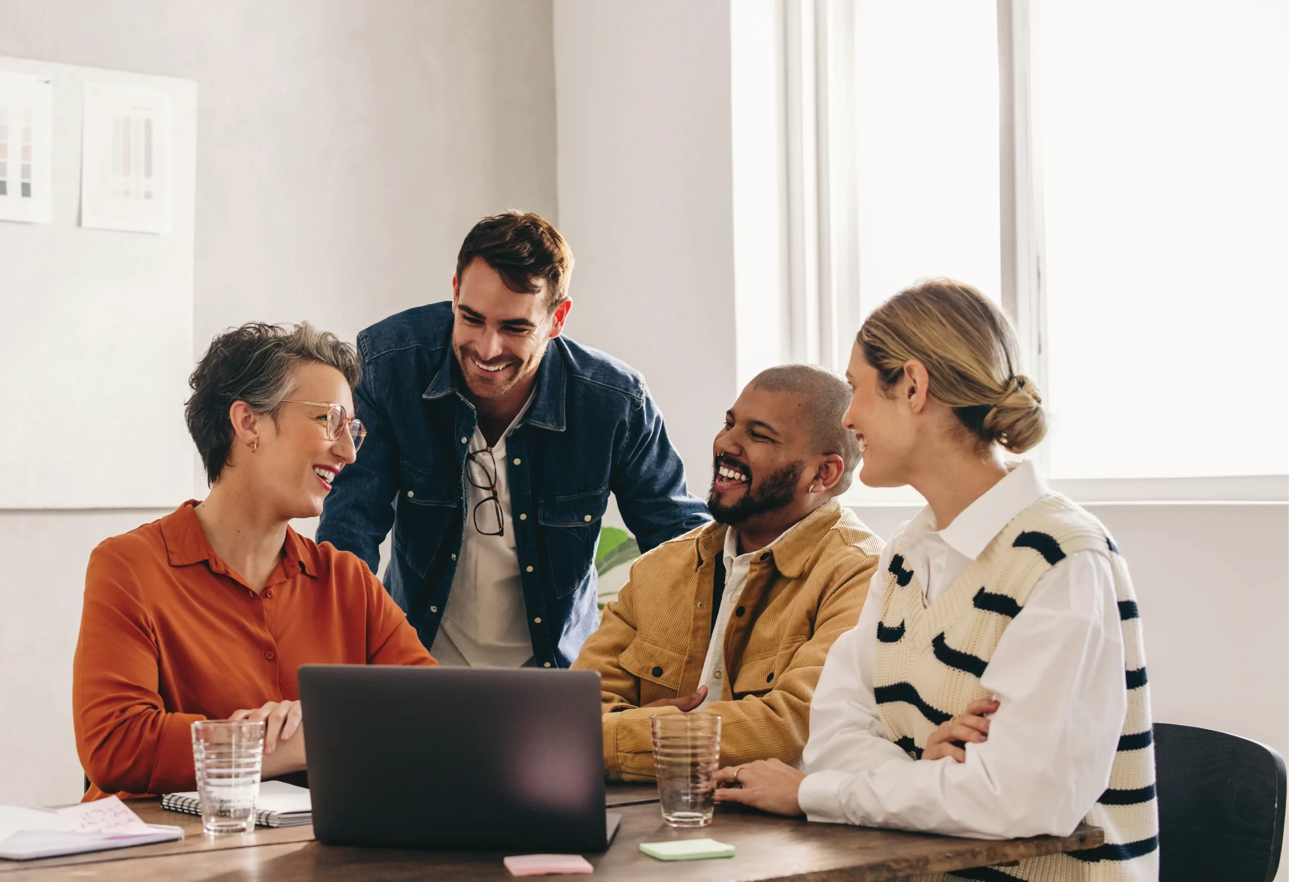 4 mature adults sitting having a meeting around a laptop