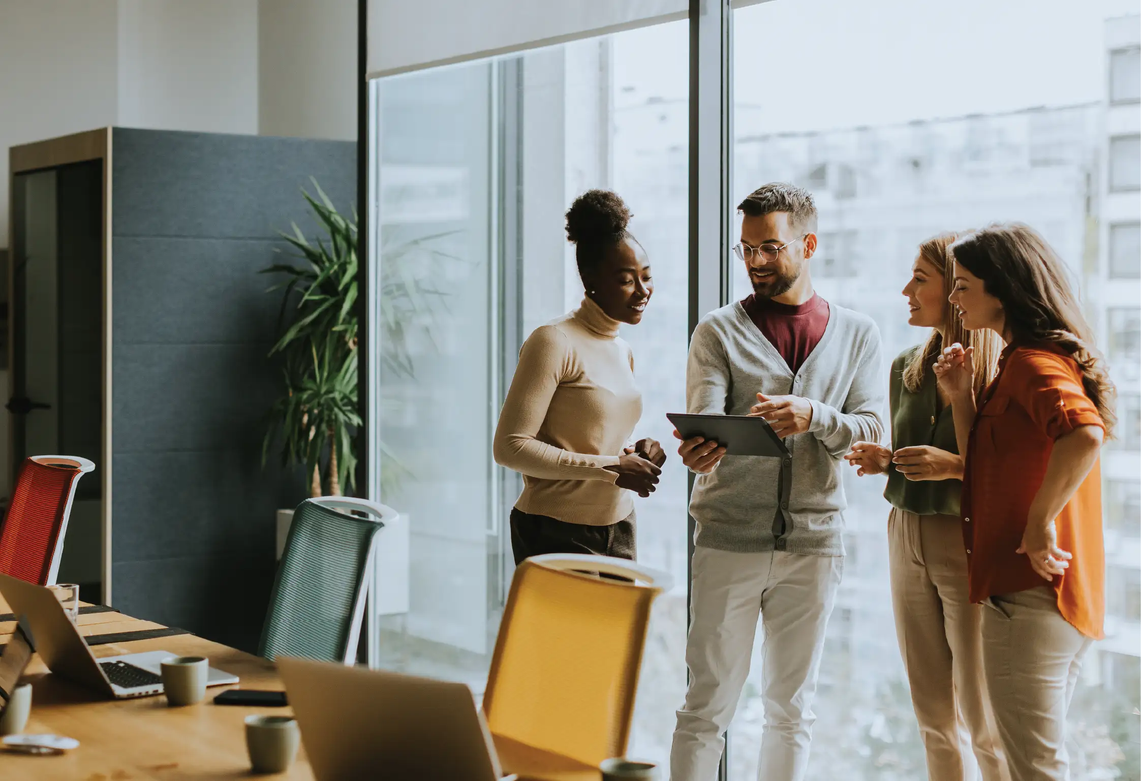 three people standing in a board room having a conversation