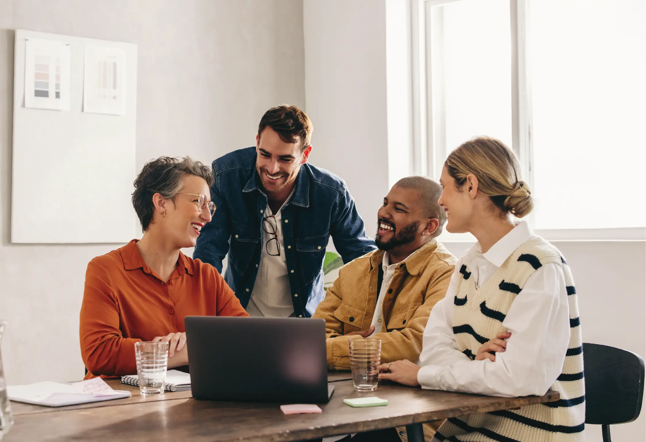 a group of four people in a meeting around a table