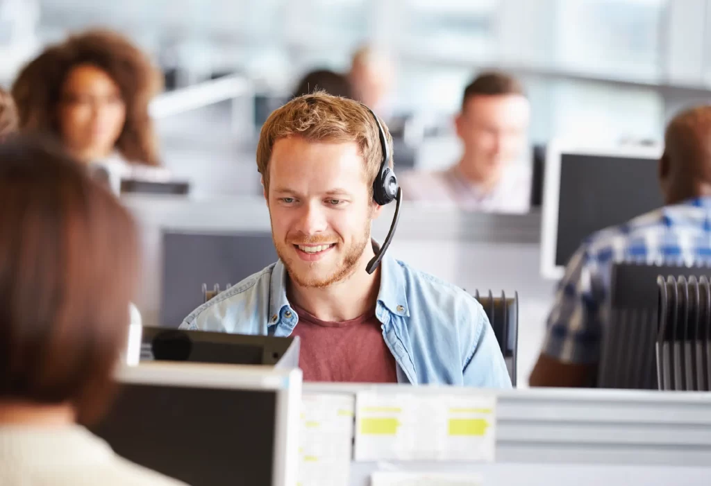 a photo of a man in a call centre on a phone call with a headset